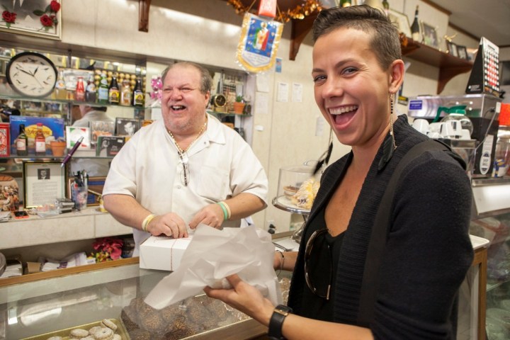 a man and woman preparing food in a kitchen